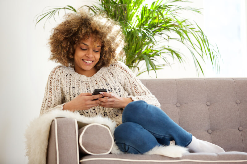 Lady using mobile on sofa